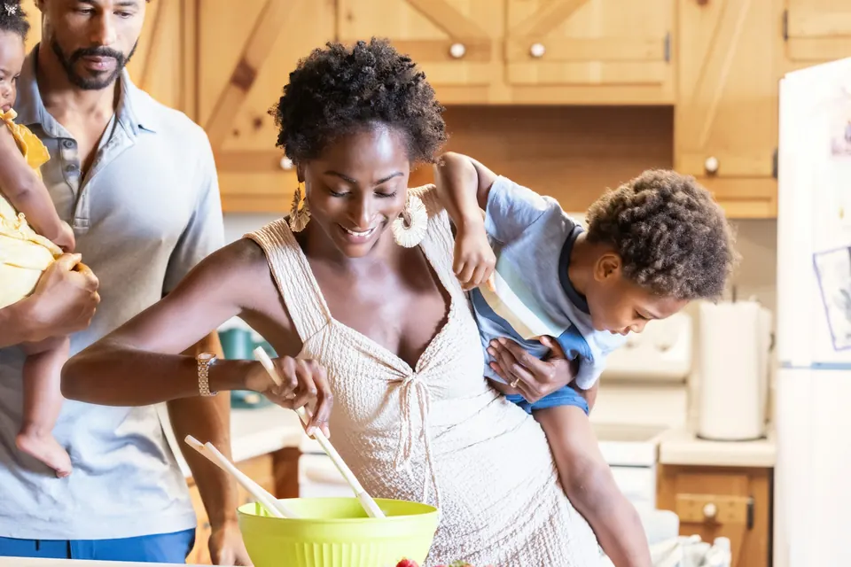 Parents et deux jeunes enfants préparant un gâteau ensemble dans la cuisine